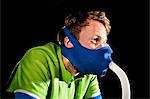 Close up of young man in face mask on gym exercise cycle in altitude centre