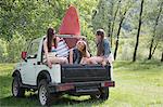 Friends sitting on back of off road vehicle