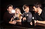 Four friends drinking bottled beer in nightclub