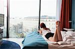 Young woman in hotel room overlooking street