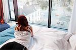 Young woman in hotel room overlooking street