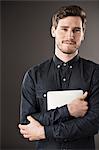 Portrait of serious businessman holding digital tablet