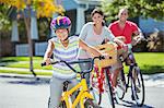 Portrait of smiling family riding bikes in street