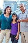 Portrait of grandparents and granddaughter in driveway