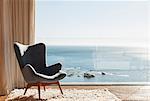 Chair in sunny window overlooking ocean