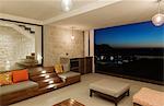 Luxury living room overlooking ocean at night