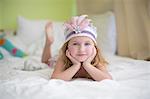 Portrait of young girl in princess headdress on bed