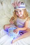 Portrait of young girl in fairy costume on bed