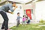 Mid adult couple with two children blowing bubbles