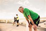 Exhausted male runners taking a break from training