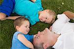 Father and sons playing on grass