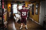 Teenage boy wearing lacrosse uniform, standing in dining room