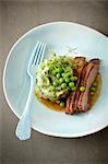 Sliced and roasted duck breast with turnips and peas