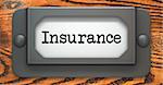 Insurance - Inscription on File Drawer Label on a Wooden Background.