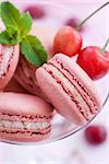 Pink french macarons with fresh cherry and mint, selective focus
