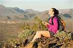 Young woman pauses at the top of a trail midway through her hike at Phoenix Sonoran Preserve in Phoenix, Arizona. She is taking a moment to self reflect.