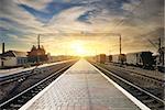 Boxcar on the station at sunset with clouds