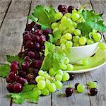 Ripe green and red grape in ceramic bowl. Selective focus.