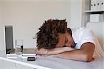 Casual businessman sleeping at his desk in his office