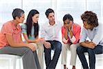 Group therapy in session sitting in a circle in a bright room