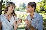 Cute couple sitting outside toasting with champagne on a sunny day