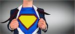 Businessman opening shirt in superhero style against grey vignette