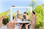 Hand holding tablet pc showing parents giving children a piggyback