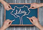 Composite image of multiple hands drawing idea tree with chalk on wooden board