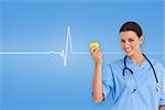 Happy surgeon holding an apple and smiling at camera against medical background with blue ecg line