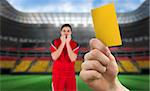 Hand holding up yellow card against stadium full of germany football fans with player