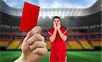 Composite image of hand holding up red card to player against stadium full of germany football fans