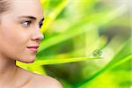 Smiling blonde natural beauty against dew on the green grass