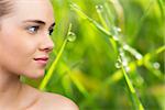 Smiling blonde natural beauty against dew on the grass