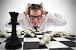 Composite image of stressed businessman touching his head with chessboard