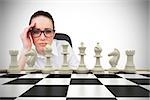 Composite image of thinking businesswoman with chessboard