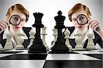 Focused businesswoman with magnifying glass with chessboard against white background with vignette