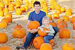 happy family having fun at pumpkin patch at fall