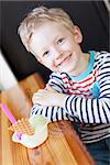 little boy enjoying ice cream in cafe