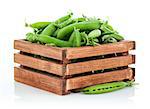 Green peas in wooden box. Isolated on white background