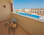 Chairs and table on tropical luxury hotel balcony with view