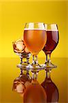 Two glasses of beer with snacks over a bright yellow background