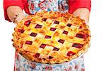 Closeup of a homemade cherry pie being held by a stereotypical grandma.  Isolated on white.