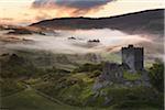 Dolwyddelan Castle, Snowdonia National Park, North Wales. Ruined castle in a misty, mountainous landscape at dawn.