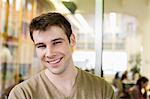 Portrait of handsome young businessman smiling in office