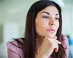 Thoughtful young businesswoman looking away in office