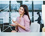 Portrait of confident businesswoman having coffee in office
