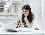 Young businesswoman using laptop at office desk