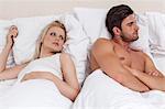 Young man ignoring woman in bed