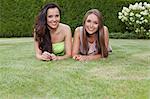 Portrait of beautiful young women with long hair lying in park