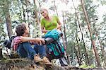 Young hiking couple looking at each other in forest